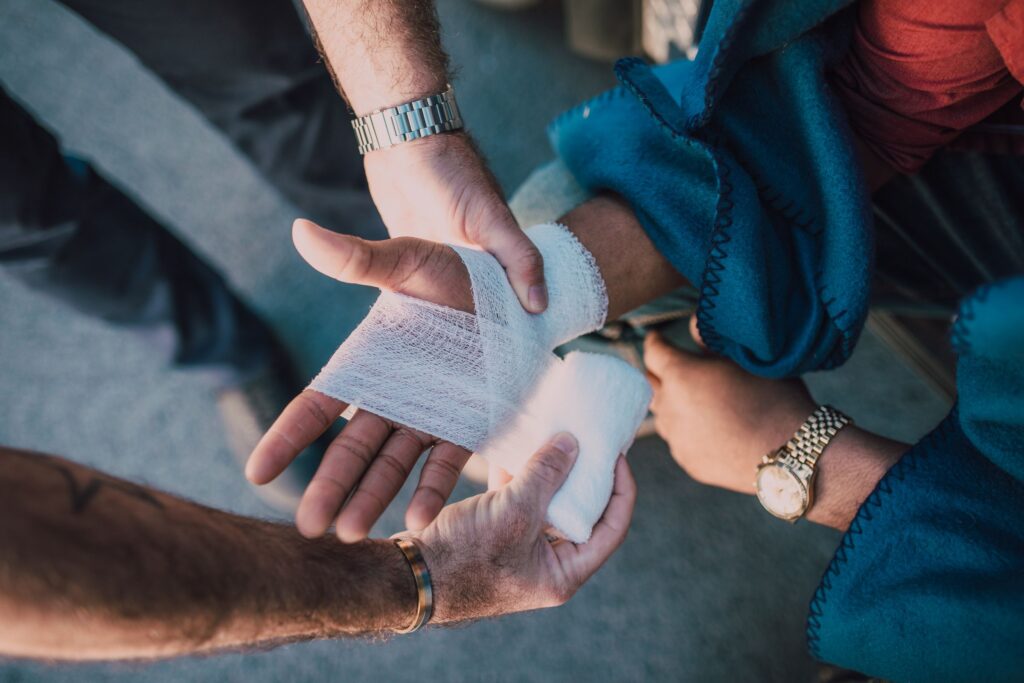 EHBO first aid instructor bandaging a participant's hand during training